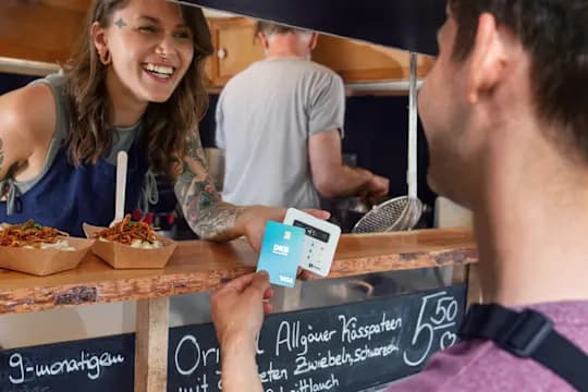 Man with Visa debit card pays at a saleswoman's card reader